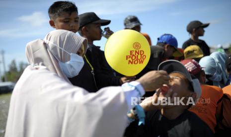 Seorang pekerja medis memberikan vaksin kepada seorang anak laki-laki saat kampanye imunisasi polio di Sigli Town Square di Pidie, Provinsi Aceh, Indonesia, Senin, 28 November 2022. Indonesia telah memulai kampanye melawan virus polio di provinsi konservatif negara itu setelah beberapa anak ditemukan terinfeksi penyakit yang sangat menular yang dinyatakan diberantas di negara itu kurang dari satu dekade lalu.