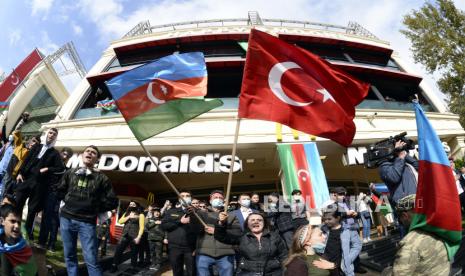  Azerbaijan merayakan pengibaran bendera nasional dan Turki di Baku, Azerbaijan, Selasa, 10 November 2020. Armenia dan Azerbaijan mengumumkan kesepakatan Selasa pagi untuk menghentikan pertempuran atas wilayah Nagorno-Karabakh di Azerbaijan berdasarkan pakta yang ditandatangani dengan Rusia yang menyerukan penyebaran hampir 2.000 penjaga perdamaian Rusia dan konsesi teritorial.