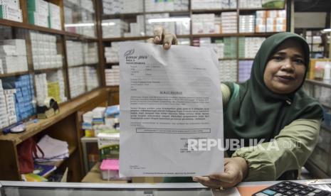 Seorang pedagang menunjukkan surat edaran larangan penjualan obat bebas dalam bentuk sirop di Pasar Pramuka, Jakarta. Presiden Joko Widodo (Jokowi) menekankan agar pemerintah memperketat pengawasan terhadap industri obat. Hal ini disampaikannya menanggapi adanya obat sirop yang diduga terkait kasus gagal ginjal akut misterius pada anak.