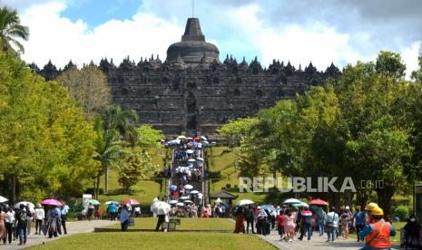 Warga berjalan-jalan saat berwisata di Candi Borobudur, Magelang, Jawa Tengah, Senin (16/5/2022). Candi Borobudur dipadati wisatawan saat Libur Hari Raya Waisak. Warga ramai berkunjung kendati diadakan acara sembahyang di Pelataran Candi Borobudur.