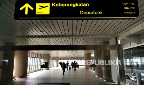 Penumpang menuju terminal keberangkatan Bandara Internasional Yogyakarta (YIA), Kulonprogo, Yogyakarta, Jumat (30/12/2022). Pembangunan pengendalian banjir YIA ditargetkan rampung pada akhir 2023.