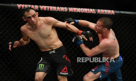 Justin Gaethje (kanan) melepas pukulan ke arah Tony Ferguson (kiri) pada laga UFC 249 di  VyStar Veterans Memorial Arena,Florida, AS, Ahad (10/5). May 9, 2020; Jacksonville, Florida, USA; Tony Ferguson (red gloves) fights Justin Gaethje (blue gloves) during UFC 249 at VyStar Veterans Memorial Arena