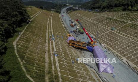 Foto udara petugas menggunakan alat berat mengevakuasi rangkaian kereta teknis proyek Kereta Cepat Jakarta-Bandung (KCJB) yang mengalami kecelakaan di Cempakamekar, Kecamatan Padalarang, Kabupaten Bandung Barat, Senin (19/12/2022). Berdasarkan keterangan Kadiv Humas Polri Irjen Dedi Prasetyo, kecelakaan tersebut menyebabkan dua warga negara China tewas serta lima orang  luka berat dan ringan. Hingga saat ini, penyebab kecelakaan kereta teknis proyek KCJB tersebut masih diselidiki pihak berwajib. Republika/Abdan Syakura