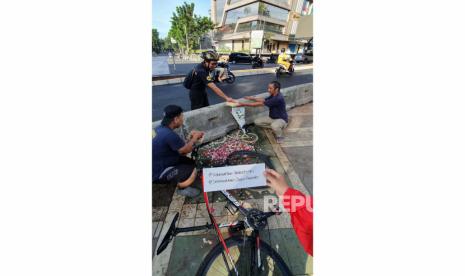 Sejumlah kelompok masyarakat menggelar aksi tabur bunga di bekas trotoar atau jalur pedestrian dan jalur sepeda di kawasan Pasar Santa, Jakarta Selatan, Ahad (16/4).