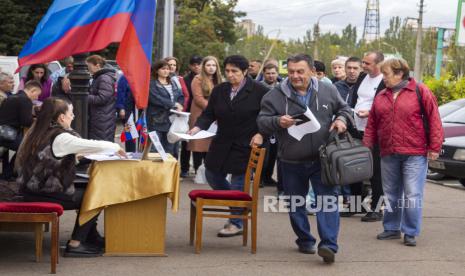 Orang-orang berbaris untuk memberikan suara dalam referendum di Luhansk, Republik Rakyat Luhansk yang dikendalikan oleh separatis yang didukung Rusia, Ukraina timur, 24 September 2022. Pemungutan suara dimulai Jumat di empat wilayah Ukraina yang dikuasai Moskow mengenai referendum untuk menjadi bagian dari Rusia .