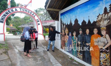 Pemandu wisata menerangkan kepada pengunjung tentang mural Bhinneka Tunggal Ika di Rumah Kebangsaan Pancasila, Desa Jogjogan, Cisarua, Kabupaten Bogor, Jawa Barat, Minggu (1/6/2021). Wisata Rumah Kebangsaan Pancasila yang berisi berbagai miniatur rumah adat dan ibadah serta patung Bung Karno tersebut menjadi wahana edukasi dan mengenalkan nilai-nilai Pancasila dalam kehidupan kebangsaan Indonesia yang merupakan bagian penting membangun karakter. Naskah Khutbah Jumat: Merawat Nikmat Persatuan