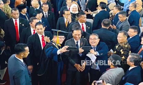 Rektor IPB University Arif Satria (memakai toga), berswafoto dengan Presiden RI Joko Widodo, usai sidang terbuka Dies Natalis ke-60 IPB University di kampus IPB Dramaga, Bogor, Jumat (15/9/2023). 