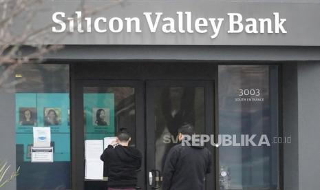 Orang-orang melihat tanda yang dipasang di luar pintu masuk Silicon Valley Bank di Santa Clara, California, Jumat, (10/3/2023), Federal Deposit Insurance Corporation menyita aset Silicon Valley Bank, menandai kegagalan bank terbesar sejak Washington Mutual selama puncak krisis keuangan 2008. FDIC memerintahkan penutupan Silicon Valley Bank dan segera mengambil semua simpanan di bank pada hari Jumat.