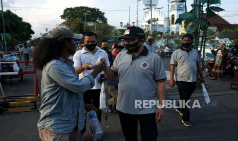 Wakil Walikota Yogyakarta, Heroe Poerwadi (ketiga kiri)  memberikan masker kepada warga saat Fun Walk PHRI DIY. Pemerintah Daerah Istimewa Yogyakarta mengimbau warga setempat untuk mengetatkan protokol kesehatan karena makin marak transmisi lokal penularan COVID-19 yang menyebabkan lonjakan kasus terkonfirmasi positif di daerah ini.