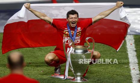 Robert Lewandowski dari Bayern Muenchen berselebrasi dengan trofi setelah Muenchen memenangkan pertandingan final Liga Champions antara Paris Saint-Germain dan Bayern Muenichen di Stadion Luz di Lisbon, Portugal, Ahad, 23 Agustus 2020. 