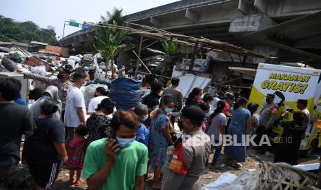 Warga mengantre makanan gratis yang dibagikan Polsek Cilandak di lapak pemulung, Pondok Labu, Cilandak, Jakarta Selatan, Rabu (29/9/2021). Pembagian makanan gratis bagi warga di lapak pemulung tersebut merupakan salah satu kepedulian Polri di tengah pandemi. 