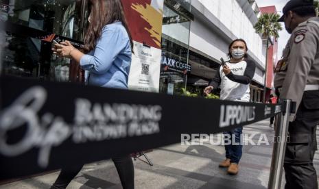 Pengunjung antre untuk memindai kode batang pada aplikasi Peduli Lindungi sebelum memasuki Bandung Indah Plaza (BIP), Jalan Merdeka, Kota Bandung, Jumat (8/7/2022). Pemerintah Kota Bandung melalui Perwal No.88 Tahun 2022 mengubah aturan kegiatan di mal dan pusat perbelanjaan di masa PPKM Level 1, yakni mewajibkan pengunjung di atas 18 tahun sudah vaksin dosis ketiga (booster) dan wajib menggunakan aplikasi Peduli Lindungi. Foto: Republika/Abdan Syakura