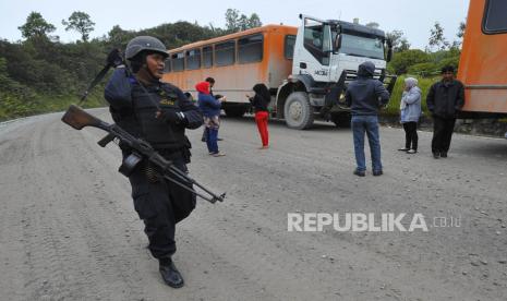 Seorang personel Brimob bersenjata lengkap melakukan penjagaan saat rombongan penumpang bus Freeport berhenti di Mile 59 kawasan PT Freeport, Mimika, Papua, Jumat (16/8). Personel Brimob, TNI serta petugas keamanan PT Freeport melakukan penjagaan rombongan bus serta patroli dari Timika ke Tembagapura untuk mengantisipasi aksi penyerangan di kawasan itu