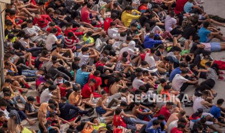 Anak di bawah umur tanpa pendamping yang menyeberang ke Spanyol dikumpulkan di luar gudang yang digunakan sebagai tempat penampungan sementara saat mereka menunggu untuk diuji COVID-19 di daerah kantong Spanyol di Ceuta, dekat perbatasan Maroko dan Spanyol, Rabu, 19 Mei 2021.