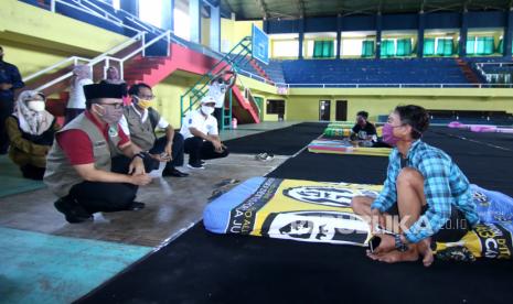 Bupati Banyuwangi Abdullah Azwar Anas (kiri) mengunjungi pemudik yang dikarantina di Gelanggang Olah Raga (GOR) Tawangalun Banyuwangi, Jawa Timur, Kamis (7/5/2020). Pemudik yang dikarantina dan terdata oleh Gugus Tugas Penanganan COVID-19 di GOR Tawangalun, selanjutnya akan dilaporakan ke perangkat daerah asalnya untuk dilakukan penjemputan dan pengawasan saat karantina mandiri di daerahnya