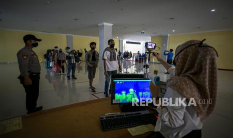 Petugas Kantor Kesehatan Pelabuhan (KKP) Batam memeriksa suhu tubuh penumpang kapal laut dari Selat Panjang di terminal kedatangan Pelabuhan Domestik Sekupang, Batam, Kepulauan Riau, Ahad (7/6/2020). Pemerintah Kota Batam memperketat protokol kesehatan dengan mewajibkan semua penumpang angkutan laut dan udara yang tiba di Kota Batam untuk menunjukkan surat keterangan Test Reverse Transcription Polymerase Chain Reaction (RT-PCR) dengan hasil negatif yang berlaku tujuh hari atau surat keterangan uji Rapid Test dengan hasil non reaktif yang berlaku tiga hari pada saat keberangkatan dari kota asal