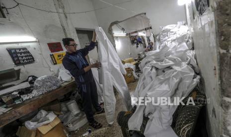 Gaza Kehabisan Alat Diagnosa Covid-19. Warga Palestina memproduksi pakaian pelindung di sebuah pabrik jahit kecil di Kota Gaza,  Senin (30/3). Beberapa pabrik pakaian di Jalur Gaza telah mengubah jalur produksinya untuk memproduksi peralatan pelindung seperti pakaian pelindung dan masker wajah medis untuk pasar Israel dan West Bank di tengah kekhawatiran tentang penyebaran pandemic penyakit COVID-19 yang disebabkan oleh SARS CoV-2 virus Corona