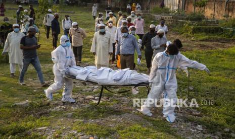  Petugas kota bersiap untuk menguburkan jenazah seseorang yang meninggal karena COVID-19 