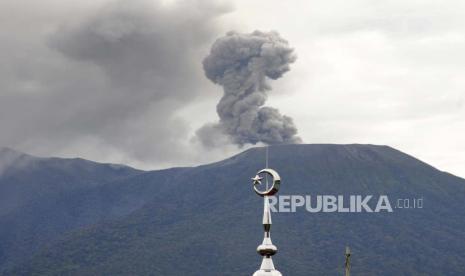 Menara masjid terlihat saat Gunung Marapi memuntahkan material vulkanik saat meletus di Agam, Sumatera Barat, Indonesia, Senin, 4 Desember 2023. Gunung berapi tersebut memuntahkan kolom abu tebal setinggi 3.000 meter (9.800 kaki) ke dalam langit dalam letusan mendadak hari Minggu dan awan abu panas menyebar beberapa mil (kilometer).