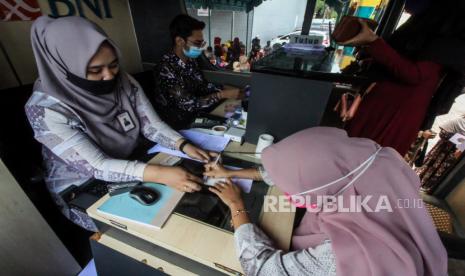 Guru honorer meneken dokumen buku tabungan bank BNI saat pencairan bantuan subsidi upah (BSU) di Lhokseumawe, Aceh, Kamis (26/11/2020). Kementerian Pendidikan dan Kebudayaan (Kemendikbud) menetapkan 2.034.732 orang terdiri guru, Dosen, Tenaga perpustakaan, Tenaga laboratorium, dan tenaga administrasi sebagai penerima BSU sebesar Rp1,8 juta dengan total anggaran Rp 3,6 triliun bersumber APBN 2020.