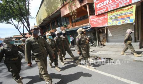 Petugas Satpol PP melakukan patroli saat pemberlakuan Pembatasan Sosial Berskala Besar (PSBB). 