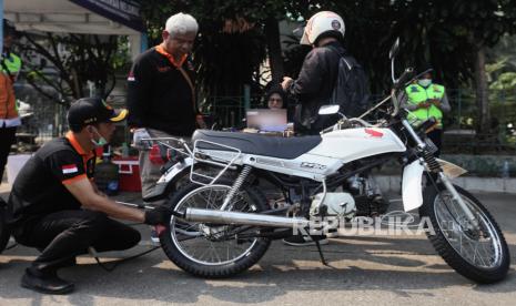 Petugas melakukan uji emisi kendaraan motor yang terjaring uji coba tilang uji emisi di Terminal Blok M, Jakarta Selatan, Jumat (25/8/2023). Pemerintah Provinsi DKI Jakarta bersama Polda Metro Jaya melakukan uji coba tilang uji emisi di lima wilayah DKI Jakarta sebelum diberlakukan sanksi tilang pada 1 September 2023. Denda sanksi tilang bagi kendaraan yang tidak lulus uji emisi sebesar Rp 250.000 bagi kendaraan motor dan Rp 500.000 bagi kendaraan mobil.