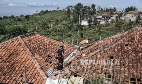 Sejumlah warga membersihkan puing reruntuhan bangunan pascabencana angin puting beliung di Desa Mekarsaluyu, Kecamatan Cimenyan, Kabupaten Bandung, Senin (29/3). Berdasarkan data dari Badan Penanggulangan Bencana Daerah (BPBD) Kabupaten Bandung, sebanyak 298 rumah, satu kantor desa, satu masjid, dua sekolah dan lahan pertanian di dua desa terdampak bencana angin puting beliung yang terjadi pada Ahad (28/3). Foto: Republika/Abdan Syakura