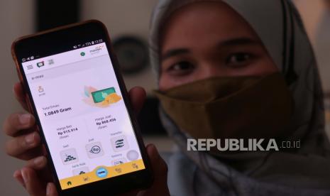 Seorang nasabah memperlihatkan bukti transaksi pembelian emas pada gawainya melalui fitur Mandiri Syariah Mobile di Jakarta, Selasa (1/12). Bank Syariah Mandiri (Mandiri Syariah) melakukan inovasi layanan digital fitur e-mas di Mandiri Syariah Mobile (MSM). Melalui fitur e-mas, nasabah dapat membeli emas mulai dari nilai minimal Rp 50.000,- Nasabah juga dapat menjual, mengambil fisik dan bahkan mentransfer saldo emasnya kepada orang lain. Fitur ini menjadi solusi untuk melakukan small investment berbentuk emas sebagai alternatif instrumen investasi yang semakin diminati masyarakat. Foto: darmawan/republika.