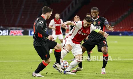 Bek Liverpool Andy Robertson (kiri) dan gelandang Georginio Wijnaldum (kanan) mengapit pemain Ajax Dusan Tadic dalam pertandingan di Johan Cruyff Arena, Amsterdam, Kamis (22/10) dini hari WIB. Liverpool menang 1-0.  EPA-EFE/MAURICE VAN STEEN