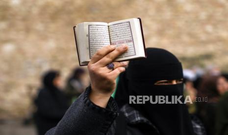 Seorang demonstran wanita memegang Alquran saat melakukan protes di depan Konsulat Jenderal Swedia, di Istanbul, Turki, 22 Januari 2023. Demonstran berkumpul setelah politikus sayap kanan Swedia-Denmark Rasmus Paludan diizinkan menggelar demonstrasi dan membakar salinan Alquran di depan kedutaan Turki di Stockholm pada 21 Januari 2023.