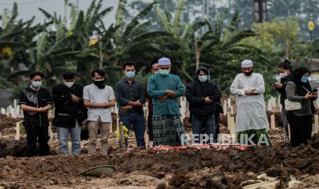 Keluarga melaksanakan shalat jenazah saat prosesi pemakaman jenazah pasien Covid-19 di TPU khusus Covid-19 Rorotan, Jakarta Utara, Selasa (13/7). Berdasarkan data Worldometers pada Selasa 13 Juli 2021 Indonesia menjadi negara dengan angka kasus harian terbanyak dengan penambahan kasus positif 40..427 orang dan angka kematian tertinggi di dunia bertambah 891 orang. Republika/Thoudy Badai