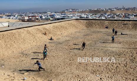 Anak-anak pengungsi Palestina bermain sepak bola di kamp pengungsi Rafah, Jalur Gaza selatan, 8 Februari 2024. 