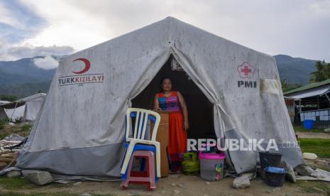 Seorang penyintas bencana berdiri di dalam tenda darurat yang dihuninya di shelter Kelurahan Balaroa, Palu, Sulawesi Tengah, Rabu (25/3/2020). Para penyintas bencana yang masih berada di tenda darurat itu meminta pemerintah agar melakukan penyemprotan di shelter tersebut karena rentan penularan akibat pemakaian bersama sarana publik