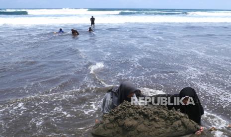 Warga berwisata di Pantai Parangtritis, Bantul, Yogyakarta. Tim SAR gabungan masih terus melakukan pencarian terhadap wisatawan yang terseret ombak di Pantai Parangtritis, Kabupaten Bantul, DIY. Di hari kedua pencarian pada Jumat (31/12), wisatawan asal Bekasi tersebut belum ditemukan.