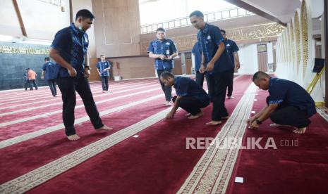 Petugas memasang tanda batas shaf (barisan) antarjamaah di Masjid Al-Muttaqien, di komplek Gedung Sate, Kota Bandung, Jumat (20/3). Pemberian jarak shaf dilakukan sebagai salah satu upaya mencegah penyebaran wabah Corona atau Covid-19.(Edi Yusuf/Republika)