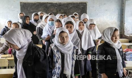 Para siswi berdiri di kelas mereka pada hari pertama tahun ajaran baru, di Kabul,  Sabtu (25/3/2023). Taliban berencana melarang organisasi internasional  memberikan pendidikan di Afghanistan.