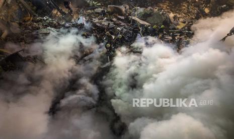 File-Petugas membersihkan puing-puing setelah roket Rusia menghantam gedung bertingkat di kota Dnipro, Ukraina, Ahad, (15/1/2023). 