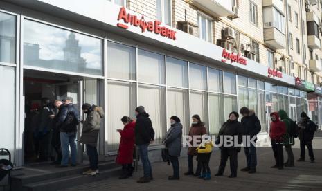 Orang-orang mengantre untuk menarik uang dari ATM Bank Alfa di Moskow, Rusia, Minggu, 27 Februari 2022. Kepala Kebijakan Luar Negeri Uni Eropa Josep Borrell mengatakan bloknya harus mempertimbangkan menyita cadangan devisa Rusia yang dibekukan untuk membantu membiayai pembangunan Ukraina pasca-perang.  