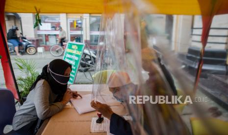 Waketum Persis: Saatnya Ulama Bangkit di Tengah Covid-19. Warga menggunakan masker saat menunaikan pembayaran zakat fitrah di Masjid Nurul Huda, Kebagusan, Jakarta, Rabu (20/5). Panitia pengumpulan zakat fitrah setempat menggunakan tirai plastik pembatas, masker, dan cairan pembersih tangan dalam melayani warga yang menunaikan zakat fitrah Ramadhan untuk mencegah penyebaran COVID-19