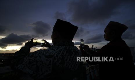 Mengenal Rukyatul Hilal untuk Menentukan Kapan Awal Puasa Ramadhan. Foto: Tim rukyatul hilal dari Nahdlatul Ulama (NU) Kota Surabaya merekam menggunakan ponsel saat mengamati posisi bulan (hilal) di atas Masjid Al-Mabrur, Nambangan, Surabaya, Jawa Timur, Ahad (1/5/2022). Dalam pengamatan tersebut tim gagal melihat bulan yang menandai awal Bulan Syawal 1443 Hijriyah atau Hari Raya Idul Fitri karena langit tertutup awan. 