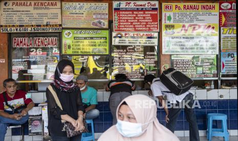 Sejumlah calon penumpang dengan mengenakan masker menunggu di depan loket, Terminal Kalideres, Jakarta Barat, Senin (26/4/2021). Meski adanya aturan larangan mudik mulai dari 22 April - 24 Mei 2021, armada perusahaan otobus (PO) tetap beroperasi di Terminal Kalideres. 