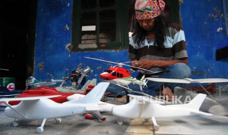 Perajin mengerjakan pembuatan miniatur pesawat dari bahan limbah kayu lame di Rumah Kreatif, Kampung Bojong Hilir RT 02/10, Desa Bojong, Kemang, Kabupaten Bogor, Jawa Barat, Selasa (30/6/2020). Presiden Joko Widodo meminta para kepala daerah turut menyiapkan anggaran dari APBD untuk memberikan bantuan stimulus pada pelaku usaha mikro, kecil, dan menengah (UMKM) di wilayah masing-masing untuk bangkit di tengah pandemi COVID-19. ANTARA FOTO/Arif Firmansyah/hp.