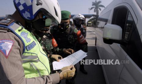 Petugas gabungan Satgas COVID-19 Kabupaten Bogor memeriksa dokumen perjalanan pengendara saat melakukan penyekatan di pintu keluar Tol Ciawi, Kabupaten Bogor, Jawa Barat  Jawa Barat, Ahad (18/7/2021). Penyekatan kendaraan di gerbang tol pintu keluar menuju jalur wisata Puncak selama Pemberlakuan Pembatasan Kegiatan Masyarakat (PPKM) Darurat itu untuk mengantisipasi penyebaran COVID-19 dan kendaraan selain plat (F) akan diputar balik. 