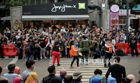 Petugas Dinas Perhubungan (Dishub) mengatur lalu lintas di area zebra cross yang dijadikan lokasi peragaan busana Citayam Fashion Week di kawasan Dukuh Atas, Jakarta, Rabu (27/7/2022). Sejumlah petugas gabungan dari Dishub dan Satpol PP melakukan penjagaan dan normalisasi fungsi zebra cross untuk penyeberangan serta perlintasan kendaraan motordan mobil. Meski demikian, kegiatan fashion show jalanan tersebut masih tetap berlangsung dengan imbauan untuk menjaga ketertiban agar tidak terjadi kemacetan. Republika/Thoudy Badai