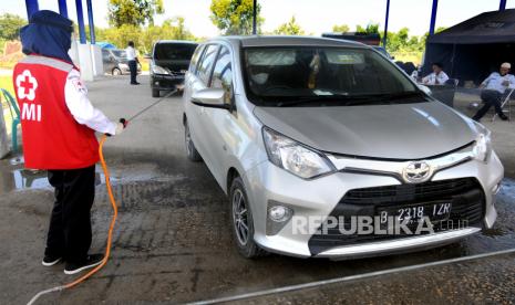 Petugas menyemprotkan disinfektan pada mobil pribadi di Pos Pantau Mudik mobil pribadi dan mobil barang di Terminal Cargo, Pamekasan, Jawa Timur, Senin (20/4/2020). Pemeriksaan pengendara mobil pribadi dan barang yang memasuki kota kota itu sebagai upaya pencegahan penyebaran COVID-19