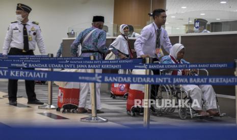 Jamaah calon haji dibantu petugas menggunakan kursi roda memasuki Bandar Udara Internasional Jawa Barat (BIJB) Kertajati di Kabupaten Majalengka, Jawa Barat, Ahad (28/5/2023). Sebanyak 374 jamaah calon haji kloter pertama asal Kabupaten Majalengka diberangkatkan menuju Tanah Suci melalui BIJB Kertajati.