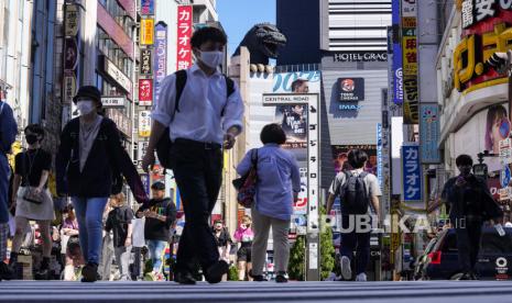 Orang-orang yang memakai masker wajah untuk melindungi diri dari COVID-19 berjalan melewati persimpangan di Shinjuku, distrik hiburan Tokyo, Senin, 20 September 2021.