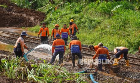 Petugas menyingkirkan material longsor yang menutup jalur rel kereta api di lintas stasiun Karanggandul-Karangsari, Banyumas, Jateng, Senin (4/12/2023). Perjalanan kereta api yang melintas di DAOP 5 Purwokerto, dialihkan memutar melalui Bandung atau Semarang imbas jalur kereta tertutup material longsor akibat curah hujan tinggi pada Senin (4/12/2024) dini hari. 