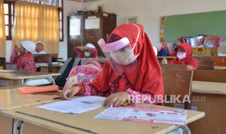 Sejumlah murid mengenakan masker dan pelindung wajah saat proses belajar mengajar di salah satu Sekolah Dasar Negeri, Desa Garut, Kecamatan Darul Imara, Kabupaten Aceh Besar, Aceh.