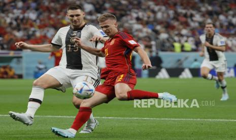  Dani Olmo (kanan) dari Spanyol beraksi melawan Niklas Suele dari Jerman selama pertandingan sepak bola grup E Piala Dunia 2022 antara Spanyol dan Jerman di Stadion Al Bayt di Al Khor, Qatar, Senin (28/11/2022) dini hari WIB..